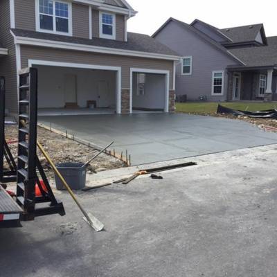 Concrete slab installation for driveway and garage at residential property in suburban area