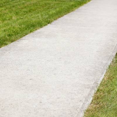 Driveway pathway leading through green grass in Brookfield, Wisconsin on a clear day